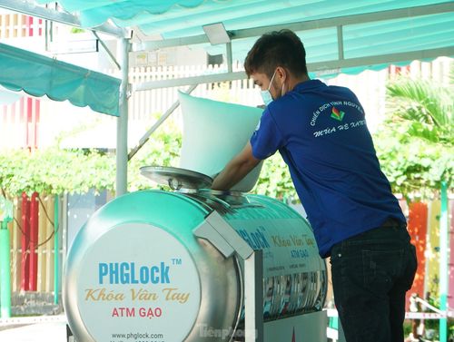 Một đoàn viên, thanh niên tiếp tế gạo vào máy để phục vụ người dân