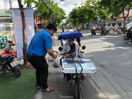 Một đoàn viên mang gạo từ ATM gạo để gửi tặng người bán vé số