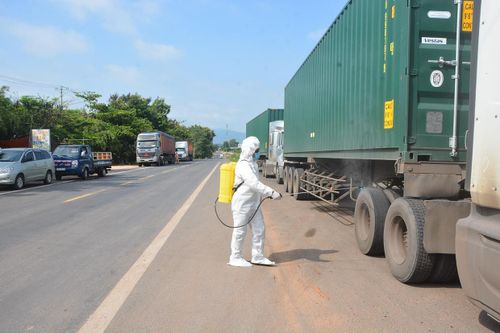 Lực lượng y tế phun thuốc khử khuẩn các phương tiện đi từ vùng dịch qua địa bàn tỉnh. Ảnh: Lê Ánh