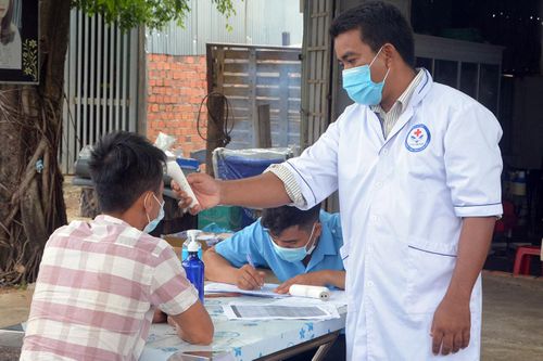 Lực lượng y tế đo thân nhiệt tài xế đi từ vùng dịch qua địa bàn tỉnh. Ảnh: Lê Ánh