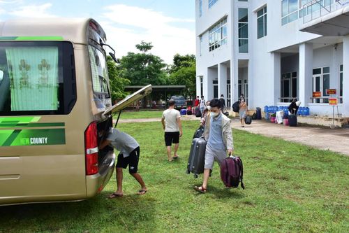 Các công dân thu xếp hành lý lên xe về địa phương cách ly. Ảnh: Ngọc Minh.
