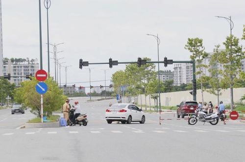 Lực lượng chức năng lập chốt và kiểm tra phương tiện tại tuyến đường trong Khu đô thị mới Thủ Thiêm. Ảnh: Trần Xuân Tình - TTXVN