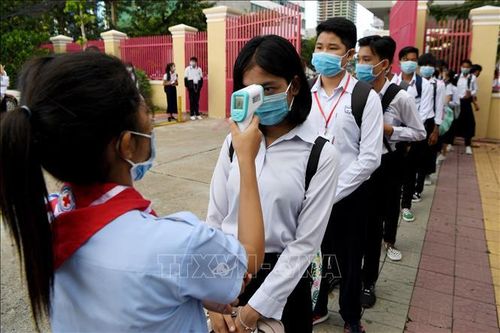 Kiểm tra thân nhiệt để phòng dịch COVID-19 tại một trường học ở Phnom Penh, Campuchia. Ảnh: AFP/TTXVN