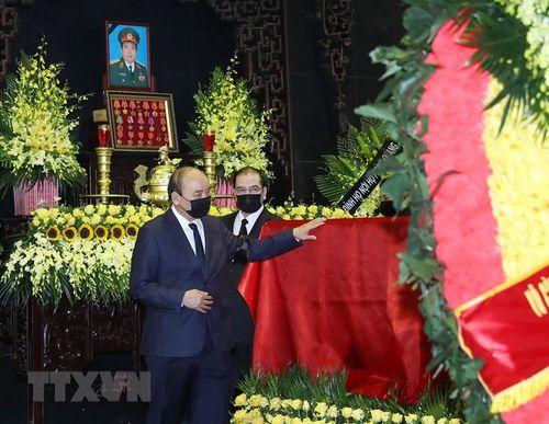  Chủ tịch nước Nguyễn Xuân Phúc đi quanh linh cữu Đại tướng Phùng Quang Thanh. (Ảnh: Trọng Đức/TTXVN)