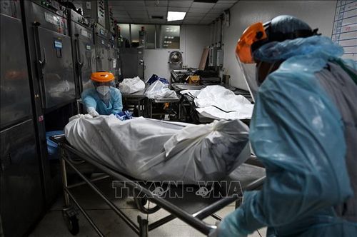 Nhân viên y tế chuyển bệnh nhân tử vong do COVID-19 tới nhà xác bệnh viện ở tỉnh Pathum Thani, Thái Lan. Ảnh: AFP/TTXVN