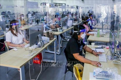 Các giáo viên được trang bị đồ phòng dịch COVID-19 khi thực hiện hỗ trợ học sinh học trực tuyến tại trung tâm Tele-Aral ở thành phố Taguig, Philippines, ngày 15/9/2021. Ảnh: THX/TTXVN