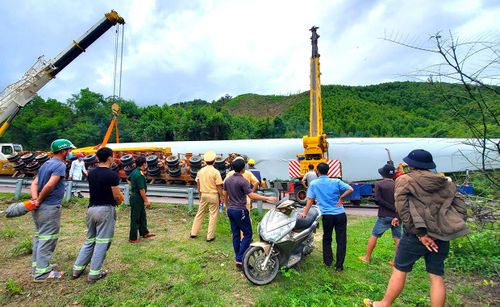 Hiện nay, đơn vị vận chuyển đang phối hợp với ngành chức năng huy động các thiết bị để cẩu xe, cánh quạt hư hỏng, giải phóng hiện trường. Ảnh: Văn Trường
