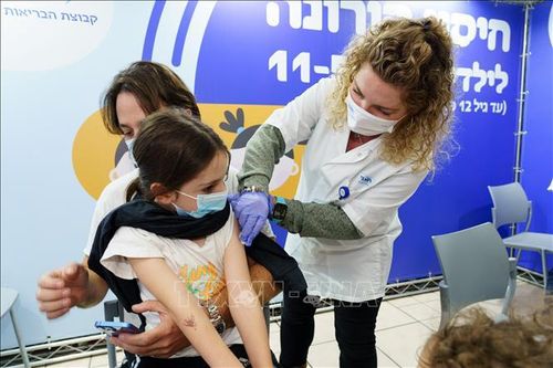 Nhân viên y tế tiêm vaccine phòng COVID-19 cho trẻ em tại Ramat Hasharon, Israel, ngày 22/11/2021. Ảnh: THX/TTXVN