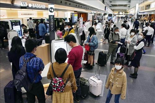 Hành khách tại sân bay Haneda ở thủ đô Tokyo, Nhật Bản. Ảnh: Kyodo/TTXVN