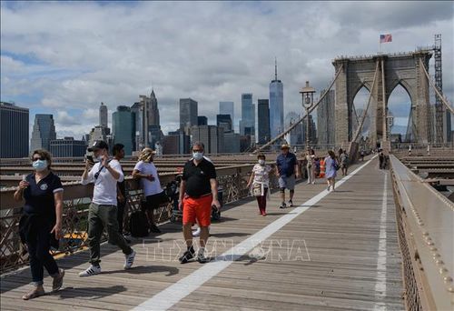 Người dân đeo khẩu trang phòng dịch COVID-19 di chuyển trên cầu Brooklyn ở New York, Mỹ. Ảnh: AFP/TTXVN