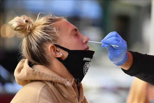 Nhân viên y tế lấy mẫu xét nghiệm COVID-19 cho học sinh tại New York City, Mỹ. Ảnh: AFP/TTXVN