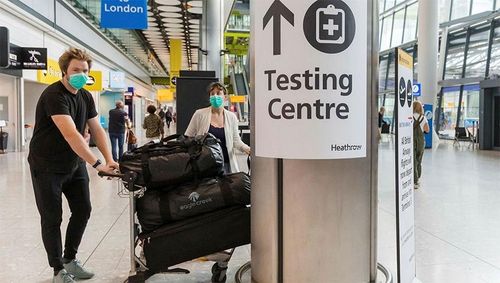 Hành khách tập trung gần một điểm xét nghiệm Covid-19 ở sân bay London Heathrow (Anh). Ảnh: EPA