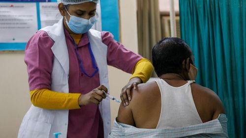 Nhân viên y tế tiêm vaccine COVID-19 cho người dân. Ảnh: Reuters