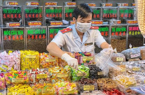 Cán bộ Ban Quản lý an toàn thực phẩm thành phố Hồ Chí Minh lấy mẫu thực phẩm tại chợ An Đông, quận 5 để kiểm tra các chất tồn dư.