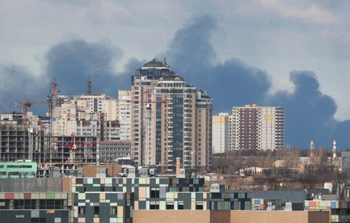 Khói bốc lên từ một tòa nhà bị pháo kích ở ngoại ô Kyiv sáng 27/2. Ảnh: Reuters.
