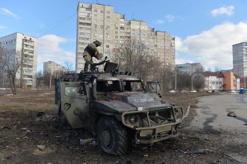  Binh sĩ Ukraine kiểm tra xe bọc thép bị phá hủy của Nga ở Kharkiv hôm 27/2. Ảnh: AFP. 