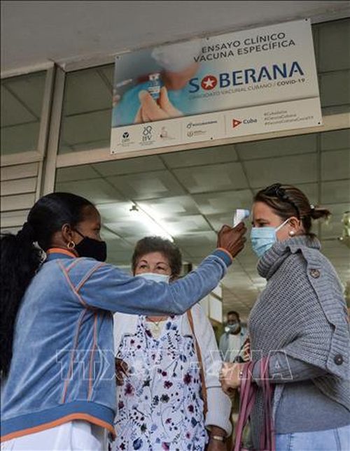 Nhân viên y tế kiểm tra thân nhiệt tại một điểm tiêm chủng vaccine ngừa COVID-19 ở Havana,Cuba. Ảnh: AFP/TTXVN
