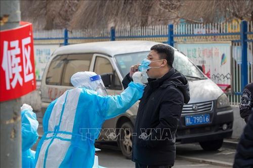 Nhân viên y tế lấy mẫu xét nghiệm cOVID-19 cho người dân tại tỉnh Cát Lâm, Trung Quốc ngày 9/3/2022. Ảnh: AFP/TTXVN