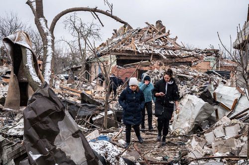  Người dân bước qua đống tàn tích bị pháo phản lực phá hủy ở Zhytomyr, Ukraine. Ảnh: Reuters. 