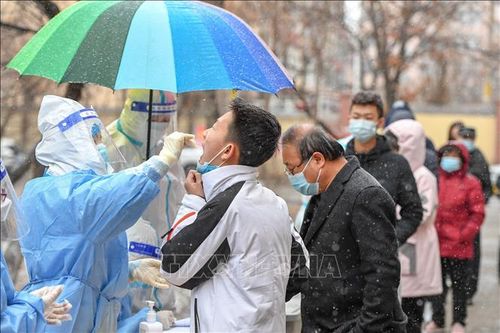 Nhân viên y tế lấy mẫu xét nghiệm COVID-19 cho người dân tại tỉnh Cát Lâm, Trung Quốc. Ảnh: THX/TTXVN