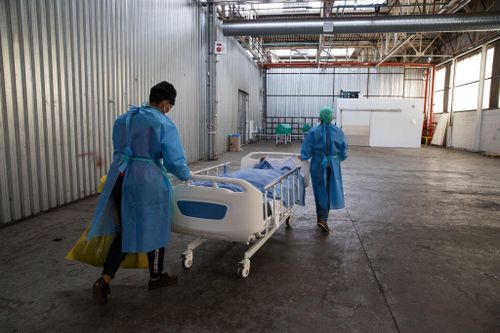  Các y tá tại một bệnh viện ở Neave, Nam Phi, di chuyển bệnh nhân qua đời vì Covid-19 đến nhà xác tạm vào tháng 11/2020. Nam Phi là quốc gia duy nhất ở châu Phi cận Sahara ghi nhận tỷ lệ nhiễm và tử vong vì Covid-19 cao. Ảnh: Samantha Reinders/The New York Times. 