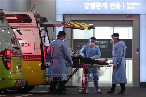 Nhân viên y tế chuyển bệnh nhân COVID-19 tới bệnh viện tại Seoul, Hàn Quốc, ngày 22/3/2022. Ảnh: THX/TTXVN