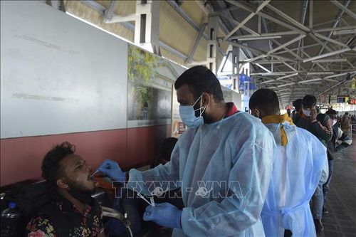 Nhân viên y tế lấy mẫu xét nghiệm COVID-19 cho người dân tại Ahmedabad, Ấn Độ. Ảnh: AFP/TTXVN