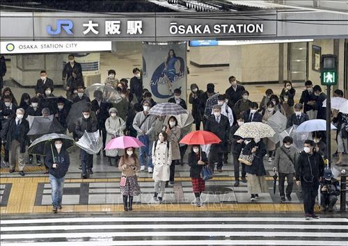 Người dân đeo khẩu trang phòng dịch COVID-19 khi đi trên đường phố ở Osaka, Nhật Bản. Ảnh: Kyodo/TTXVN