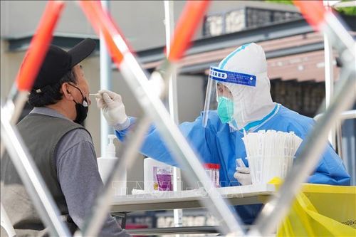 Nhân viên y tế lấy mẫu xét nghiệm COVID-19 cho người dân tại Bắc Kinh, Trung Quốc. Ảnh: THX/TTXVN