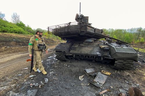 Lính Ukraine cạnh xe tăng T-90M Proryv của Nga gần làng Staryi Saltiv ở vùng Kharkiv, Ukraine ngày 9/5. Ảnh: Reuters.