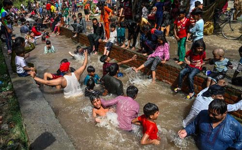 Người dân tắm mát ở một con kênh. Ảnh: Arif Ali / AFP / Getty Images.