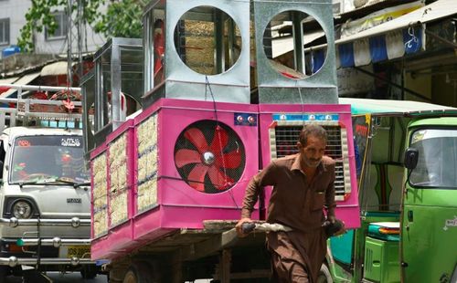 Một người lao động kéo một chiếc xe đẩy tay chất đầy máy làm mát không khí. Ảnh: Farooq Naeem / AFP / Getty Images.