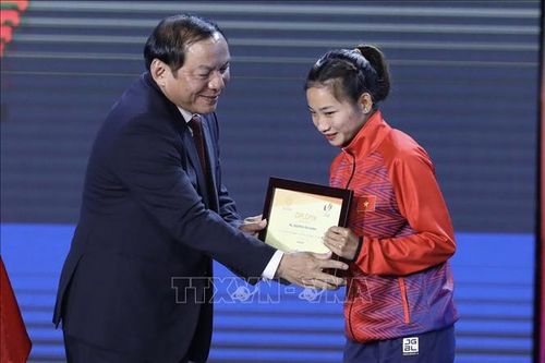 Ông Nguyễn Văn Hùng, Bộ trưởng Bộ Văn hóa, Thể thao và Du lịch, Chủ tịch Liên đoàn thể thao Đông Nam Á, Chủ tịch Ủy ban Olympic Việt Nam, Trưởng Ban tổ chức SEA Games 31 vinh danh VĐV Nguyễn Thị Oanh (Việt Nam, 3 HCV). Ảnh: TTXVN
