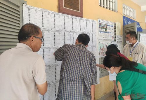 Các cử tri kiểm tra tên mình trong danh sách bầu cử. (Ảnh: Nguyễn Hiệp)