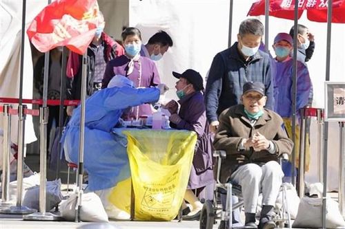 Nhân viên y tế lấy mẫu xét nghiệm COVID-19 cho người dân tại Bắc Kinh, Trung Quốc. (Ảnh: Kyodo/TTXVN)