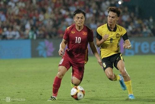 Tiền vệ Lý Công Hoàng Anh (trái) tranh bóng với cầu thủ Malaysia ở bán kết SEA Games 31 trên sân Việt Trì, Phú Thọ tối 19/5. Ảnh: Ngọc Thành