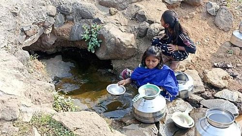 Trẻ em gái ở làng Dandichi Bari, bang Maharashtra, miền tây Ấn Độ, đổ nước vào chậu - Ảnh: AN