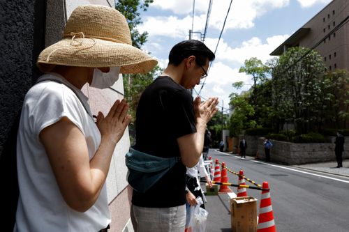  Người xếp hàng cầu nguyện bên ngoài nhà riêng của cố Thủ tướng Abe sáng 10/7. Ở Nara, cách Tokyo khoảng 450 km về phía tây nam, dòng người cũng xếp hàng để đặt hoa bên cạnh bức ảnh của ông Abe tại điểm tưởng niệm nơi ông bị bắn. 