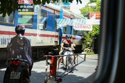  Nhiều người vẫn ở trong khu vực rào chắn khi có đoàn tàu chạy qua. Ảnh: Đoàn Nguyên. 