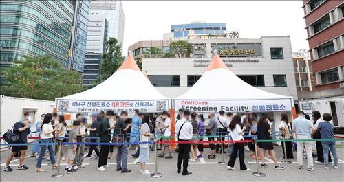Người dân chờ xét nghiệm COVID-19 tại điểm xét nghiệm ở Seoul, Hàn Quốc ngày 12/7/2022. Ảnh: YONHAP/TTXVN