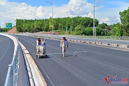 Công nhân đang hoàn thiện một số hạng mục cuối như sơn vạch kẻ đường, lắp biển báo
