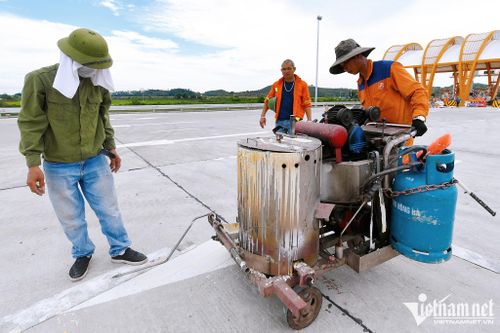Chiều 30/8, công nhân hoàn thiện vạch kẻ đường, trang trí nốt những phần cuối cùng tại trạm thu phí phía đầu Móng Cái.