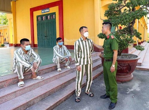 Cán bộ trại giam Ninh Khánh động viên phạm nhân T.M.C được đề nghị đặc xá năm 2022. (Ảnh: Phạm Kiên/TTXVN)