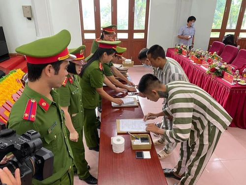 Các phạm nhân ký giấy tờ hưởng chính sách đặc xá đợt này. ( Ảnh báo PLXH) 