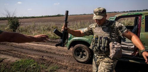 Binh sĩ Ukraine chuyển vũ khí cho nhau ở khu vực Kherson. Ảnh: Getty Images