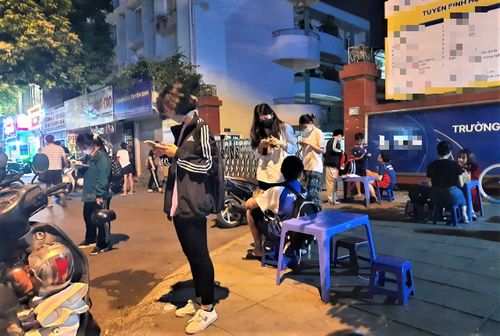 Học sinh tan ca học thêm lúc 21 giờ đang chờ bố mẹ tới đón.