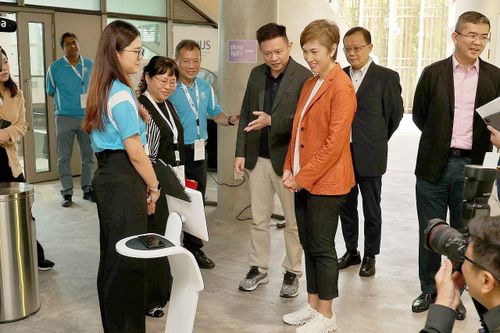 Các cán bộ trường Đại học Quốc gia Singapore giới thiệu với Bộ trưởng Bộ Thông tin và Truyền thông Josephine Teo về một robot trợ giúp đặc biệt. (Nguồn: Straits Times)