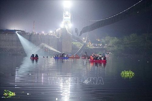 Lực lượng cứu hộ tìm kiếm các nạn nhân và giải cứu những người mắc kẹt tại hiện trường sập cầu treo trên sông Machchu ở Morbi, bang Gujarat, Ấn Độ, rạng sáng 31/10/2022. Ảnh: AFP/TTXVN