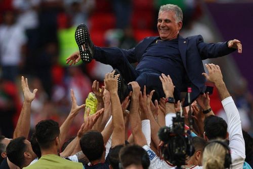  HLV Carlos Queiroz (áo đen) được tung hô sau khi giúp Iran giành chiến thắng lịch sử. 