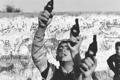 Bức ảnh đoạt giải WorldPress Photo năm 1993. Những cậu bé giương cao súng đồ chơi trong một cử chỉ thách thức ở Palestine. (ảnh: Larry Towell)
